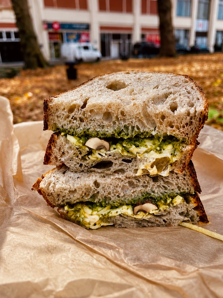 A stacked sandwich served on paper at an outdoor table