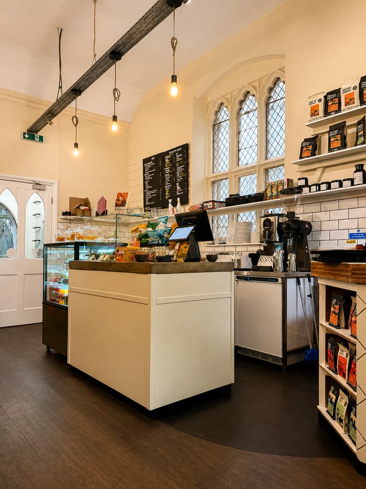 The cafe counter, espresso machine and arched windows inside Vestry Hall Coffee