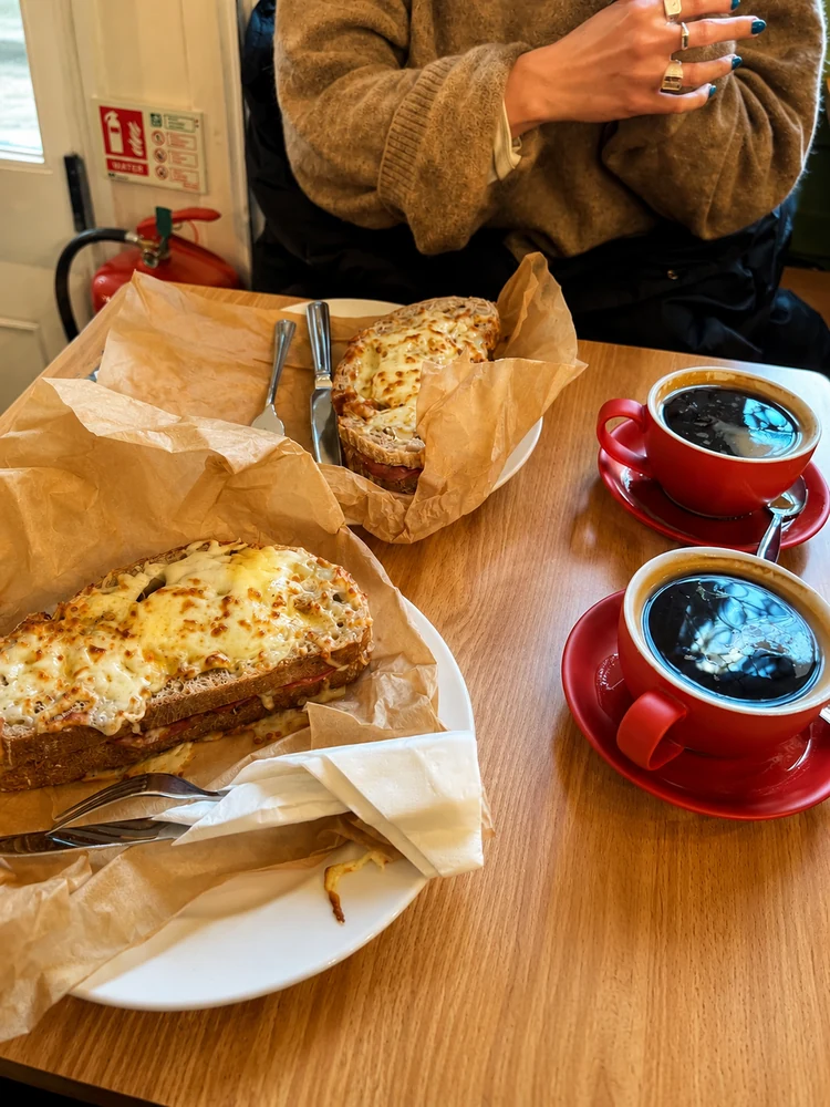 Cheese toasties and coffee served at a wooden table
